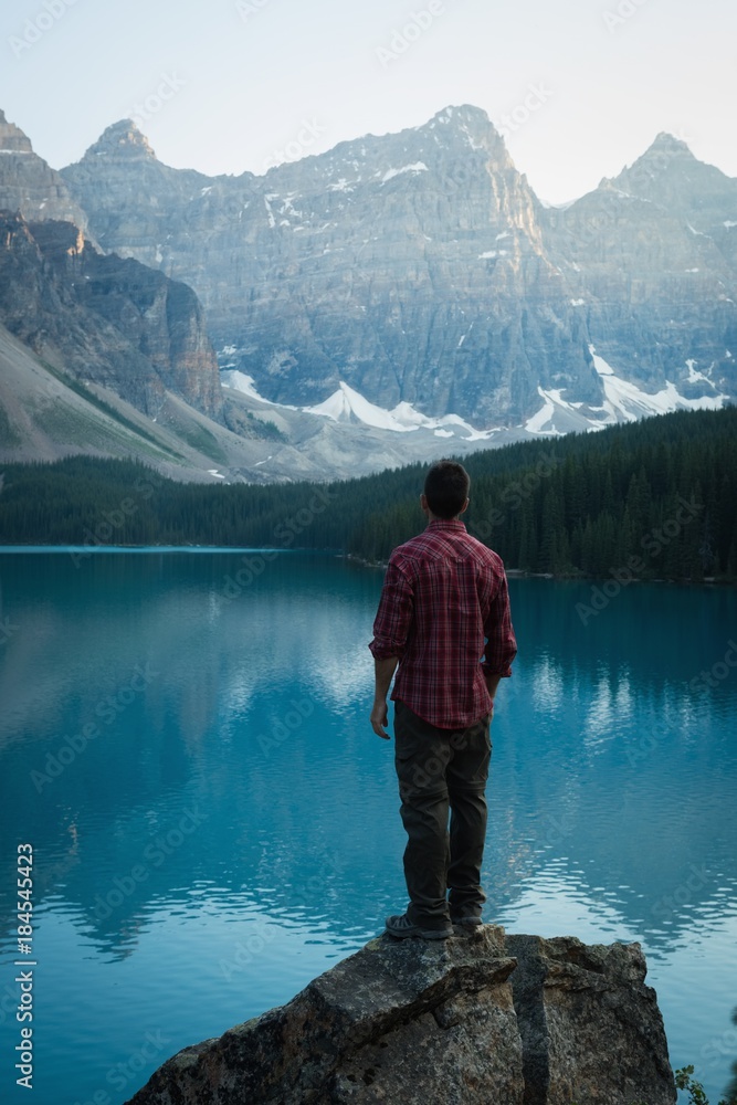 Rear view of man standing near lake side Rear view of man standing near lake side