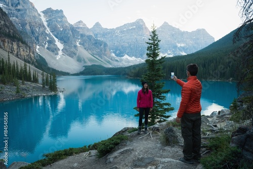Man taking picture of woman with mobile phone photo