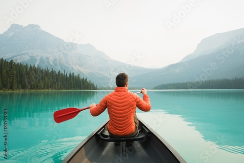 Rear view of man kayaking in lake photo