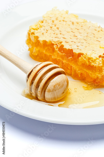 Honeycomb with honey on plate isolated white background