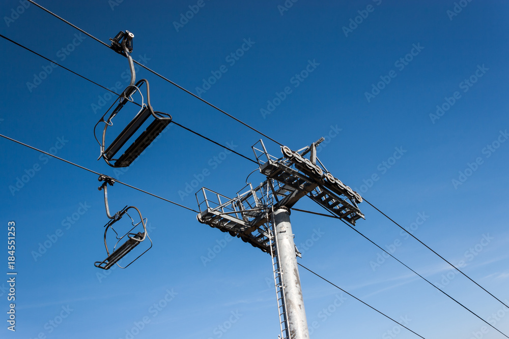 Chairlifts on a blue clear ski during on a bright day Chairlifts on a blue clear ski during on a bright day