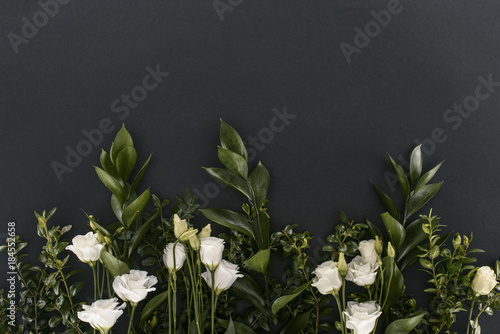 Fototapeta Naklejka Na Ścianę i Meble -  top view of eustoma flowers and branches over black background