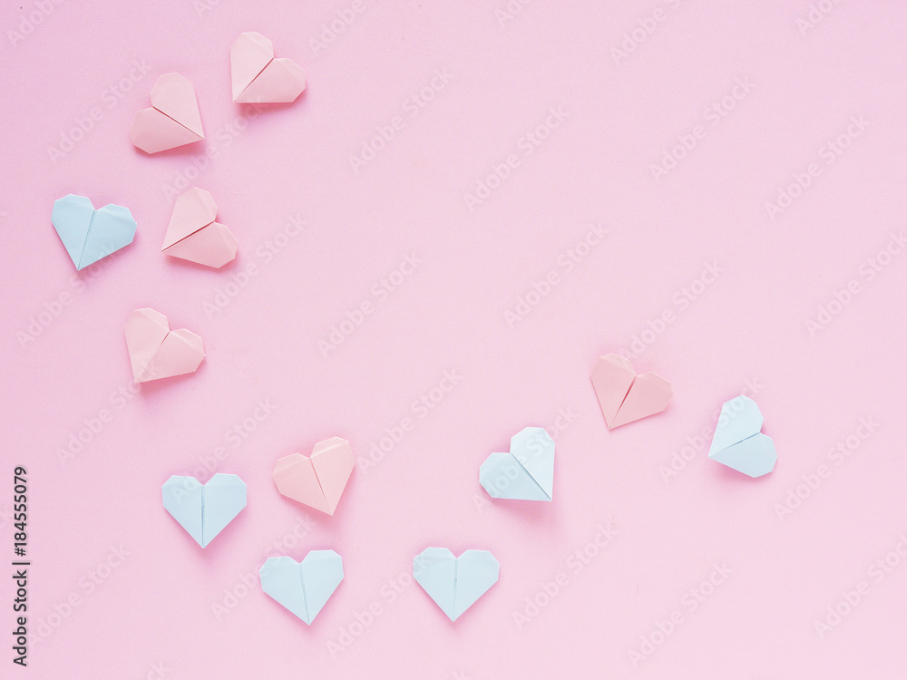 Pattern of paper origami hearts on a pink background. Valentine's day background. The hearts are blue and pink.