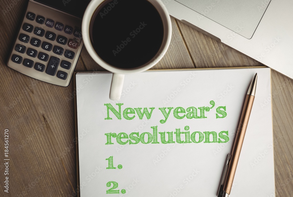 Top View of new years resolution written on notepad with cup of coffee Top View of new years resolution written on notepad with cup of coffee