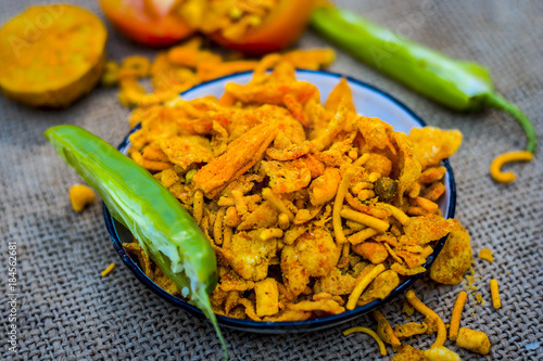 Close up Indian snack mix chevdo in a plate with green chillies. photo