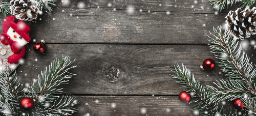 Wallpaper Mural Panoramic Christmas theme with fir branches, snowman handmade toy, cones, on rustic dark wooden background viewed from above, top, in snow greeting card with space for text Torontodigital.ca