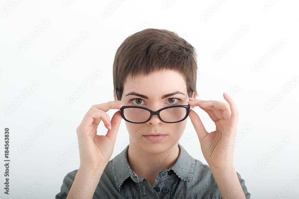 Young woman staring over her glasses. Strict teacher wearing spectacles