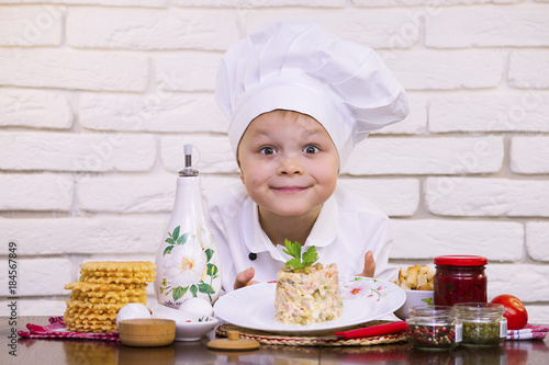 funny boy chef preparing salad Olivier photo