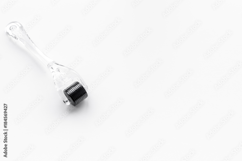 Cosmetoligist's instruments. Dermaroller on white background top view copyspace Cosmetoligist's instruments. Dermaroller on white background top view copyspace