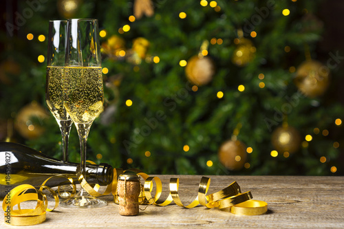 Toast Champagne, flutes on wooden floor, Christmas tree background