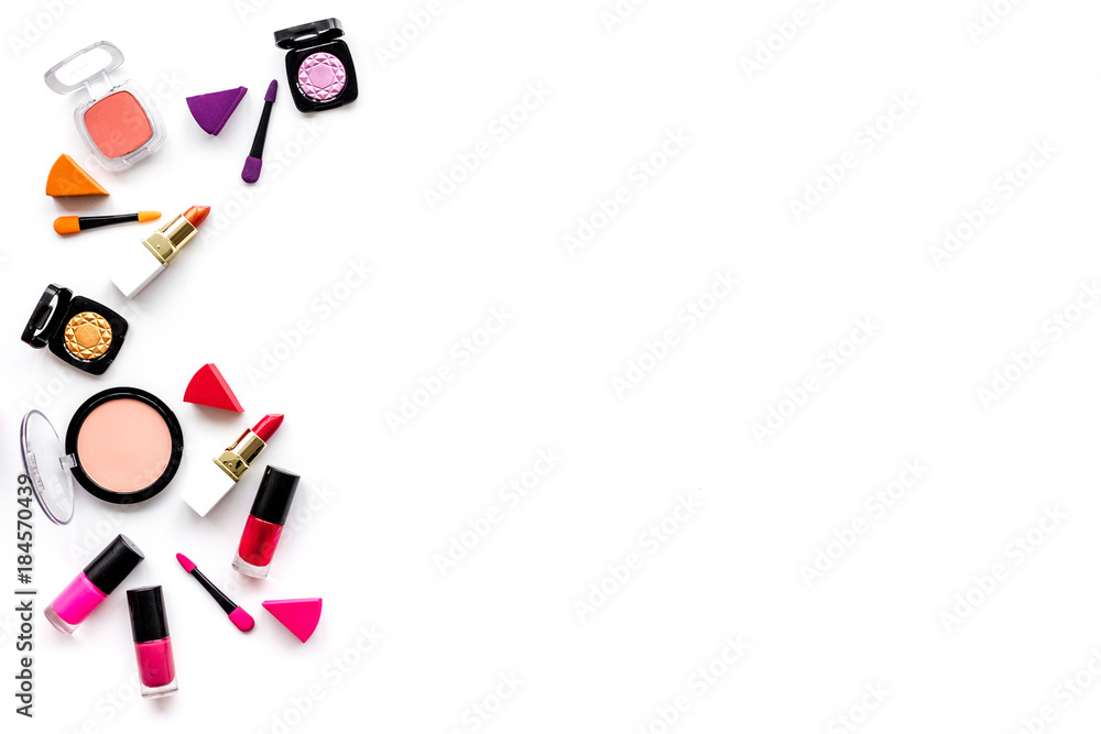 Makeup set pattern. Eyeshadows, rouge, nailpolish, lipstick, applicators on white background top view copyspace