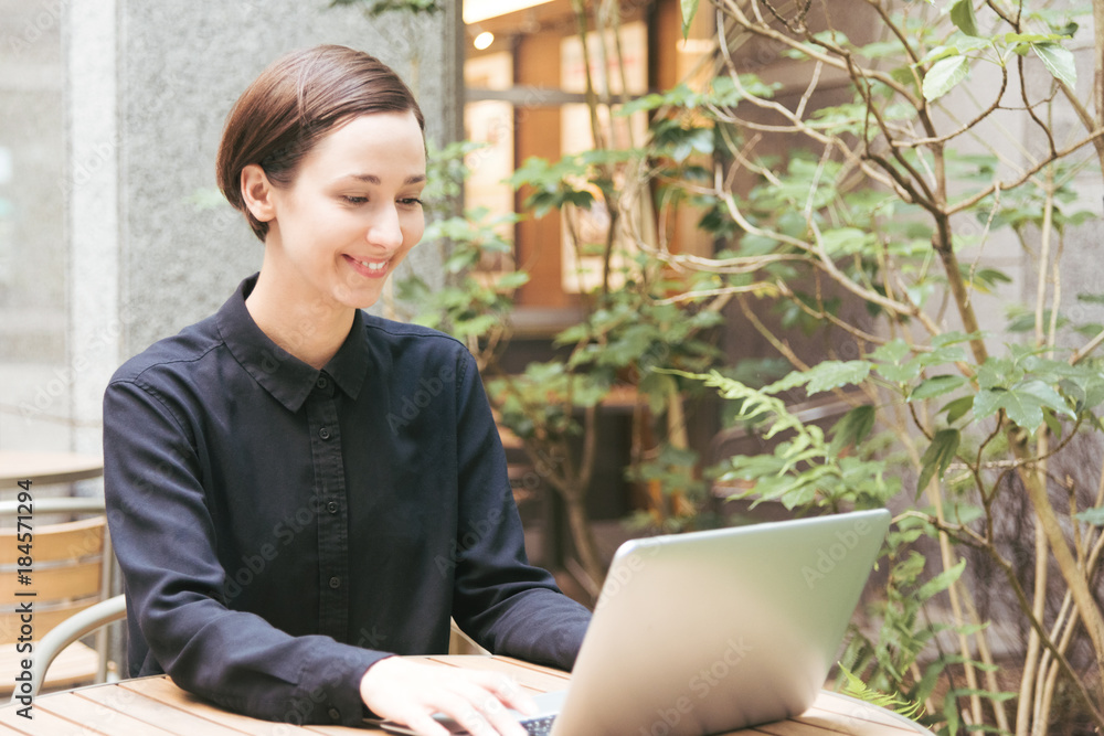 屋外のテラスで仕事をする若い女性 屋外のテラスで仕事をする若い女性