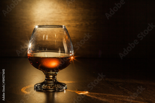 Cognac drinks glass on dark background photo