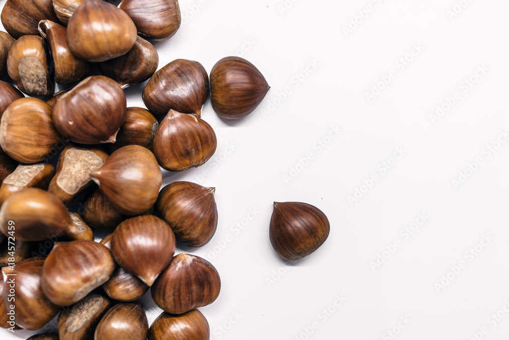 Chestnuts on a blank (white) background. Chestnuts arranged on left side with copy space. Chestnuts on a blank (white) background. Chestnuts arranged on left side with copy space.