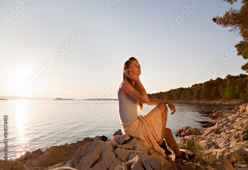 Woman listening to shell at beach