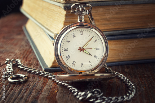 vintage watch on a chain on a background of old books