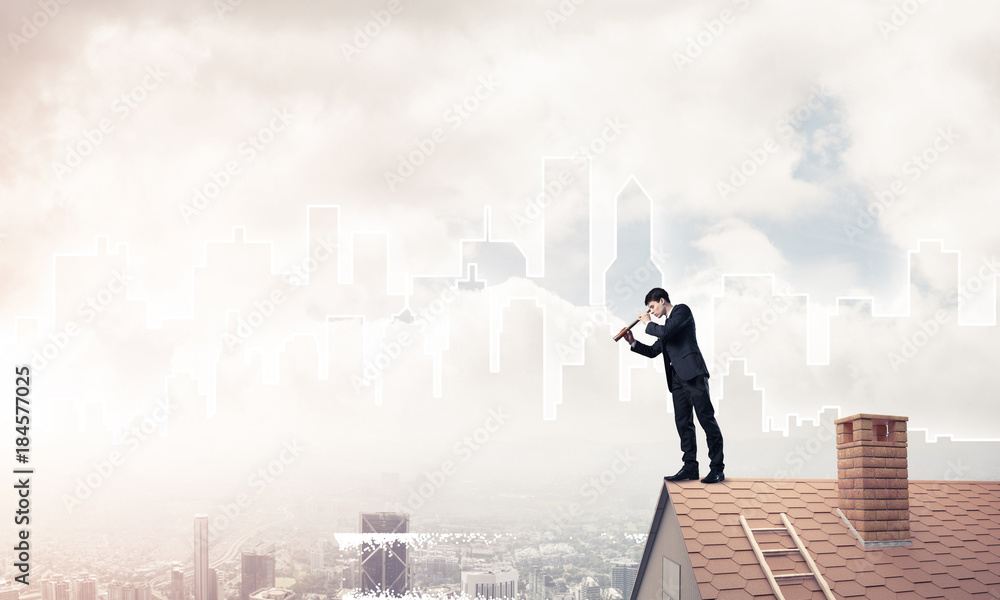 Engineer man standing on roof and looking in spyglass. Mixed med Engineer man standing on roof and looking in spyglass. Mixed med