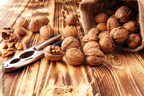 Walnut kernels and whole walnuts on table with a nutcracker