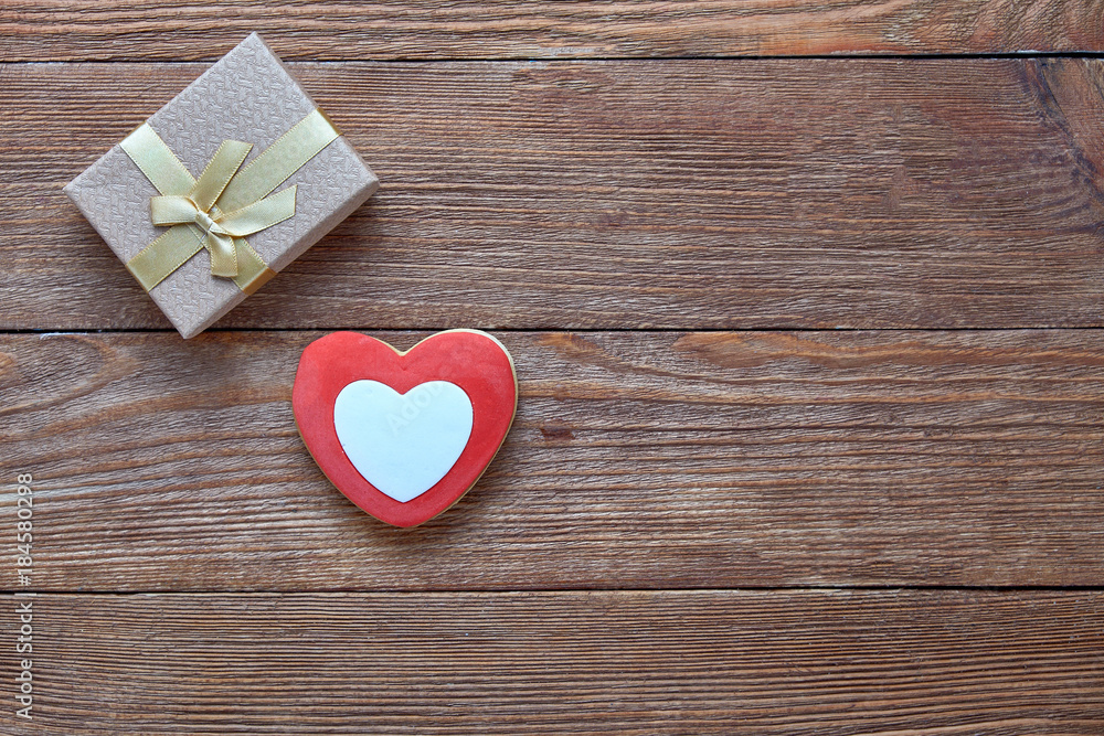 Valentine's Day. Red heart and gift box on a wooden background. Valentine's Day. Red heart and gift box on a wooden background.