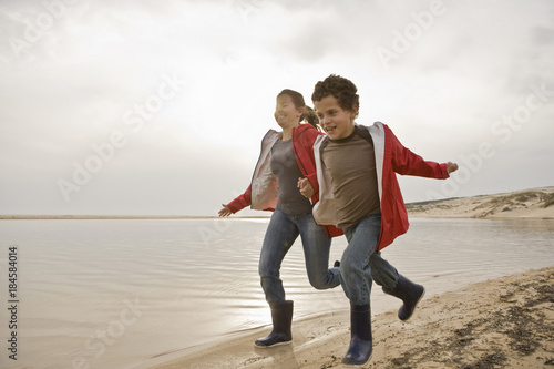 Mother and son running together on beach