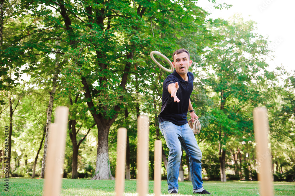 Boy playing a game throwing rings outdoors in summer park Boy playing a game throwing rings outdoors in summer park