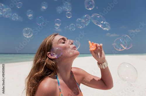 Woman blowing bubbles on beach
