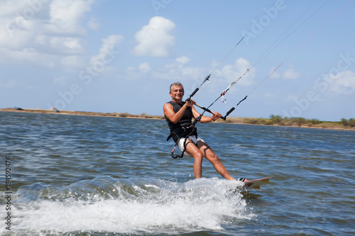 Photography Older man wind surfing on lake