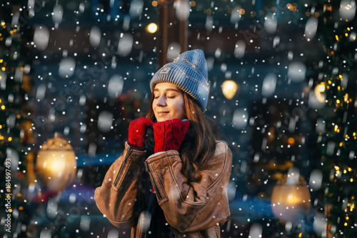 Photography Cute woman closing eyes and dreaming in winter city a festive mood