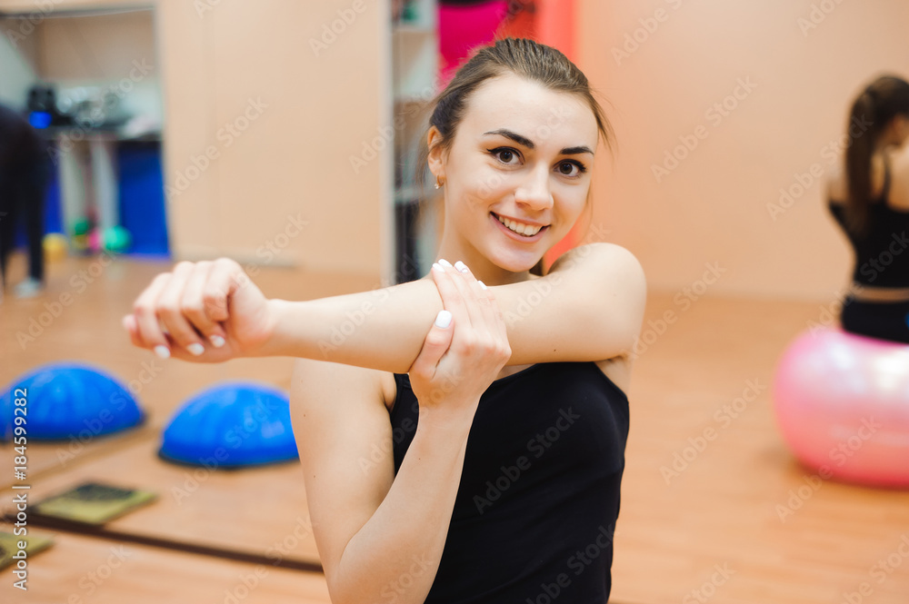 Naklejka premium happy cutie athletic girl , execute exercise and smile, in sport-hall