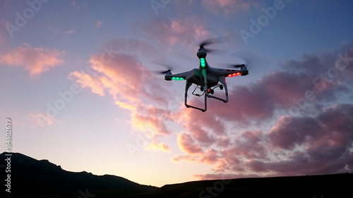 Silhouette of drone above the hills in evening skies