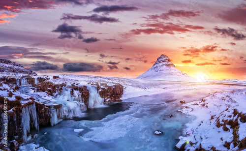 Kirkjufell mountain with frozen water falls in winter, Iceland. photo
