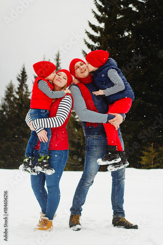 Mother, father and two sons having fun in snow winter