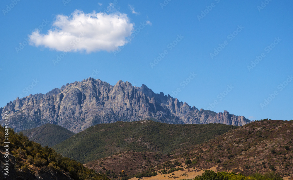 Corsica, 31/08/2017: il paesaggio selvaggio dell'entroterra corso con vista del profilo del Monte Cinto (2.706 metri), la montagna più alta dell'isola e una delle vette più importanti d'Europa