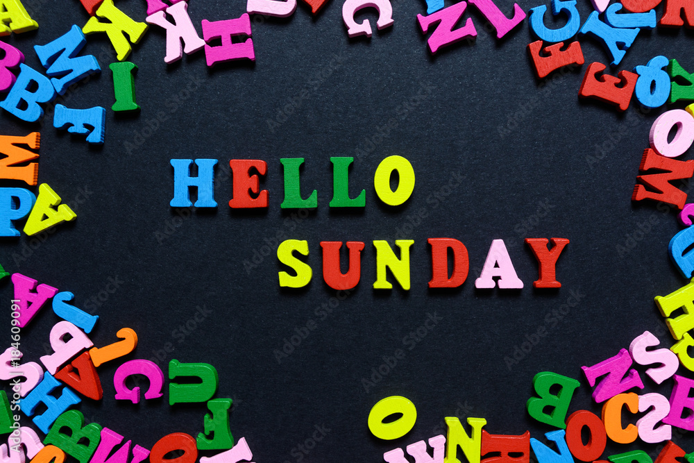 Fototapeta premium concept design - the word HELLO on SUNDAY from multi-colored wooden letters on a black background, creative idea