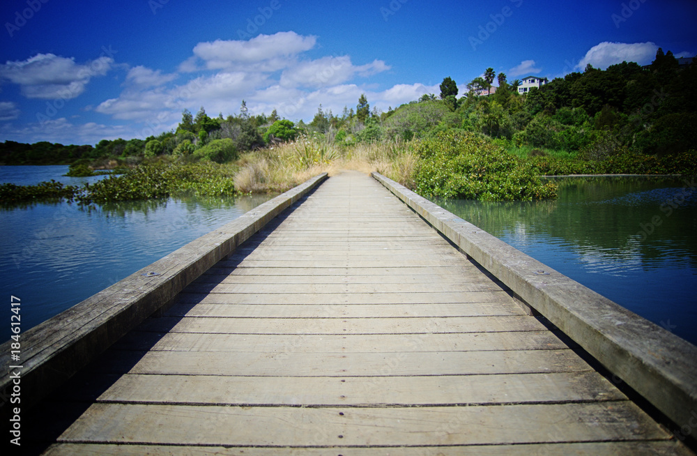 Travelling concept. Wooden pier close up, Lake, nature and blue sky in the background.
