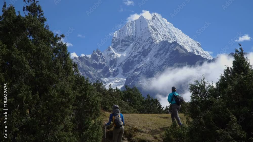 Girls of the tourist go along the trail in the Himalayas. A view of the beautiful snow top of Kangtega. Enjoys adventure and travel concept. 4K Girls of the tourist go along the trail in the Himalayas. A view of the beautiful snow top of Kangtega. Enjoys adventure and travel concept. 4K