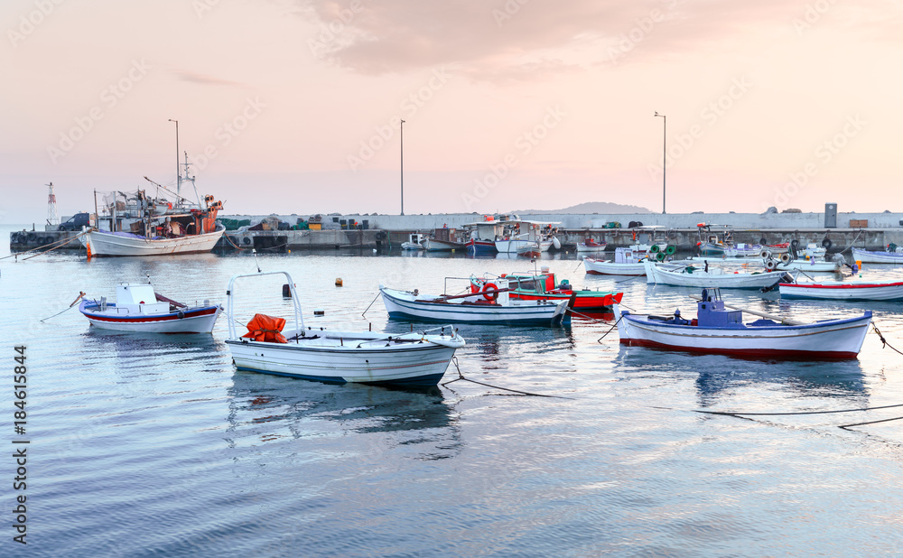 Greece, small port in coastal town Olimpiada (near Kavala) on Aegean sea. Dawn scenery of seafront. Fishing boats anchored to quay, beautiful morning landscape.