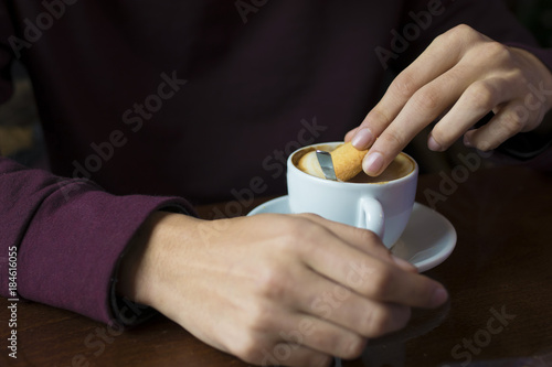hand with coffee cup in the foreground