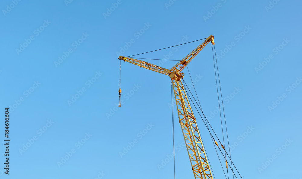 Silhouettes of tower crane on the sky background