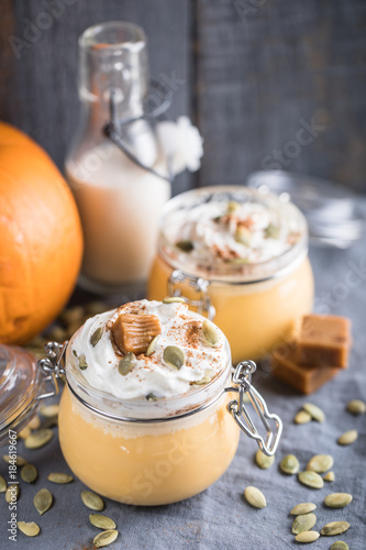 Pumpkin milkshake with salted caramel, orange, seads and wipped cream photo