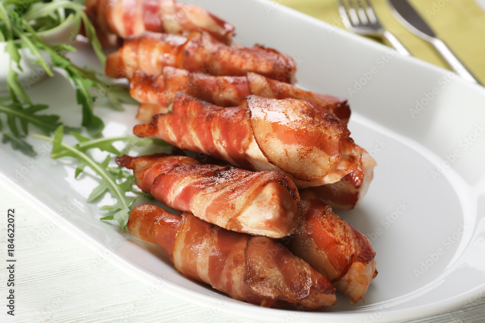 Plate with bacon wrapped chicken nuggets on table, closeup Plate with bacon wrapped chicken nuggets on table, closeup