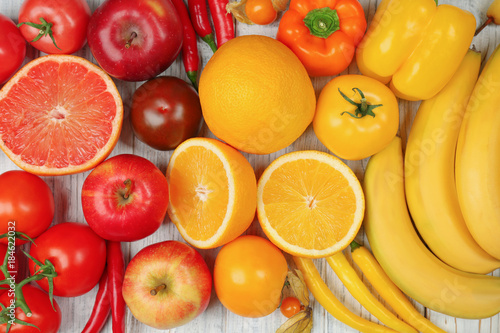 Creative composition made of fruits and vegetables in rainbow colors on wooden background, flat lay