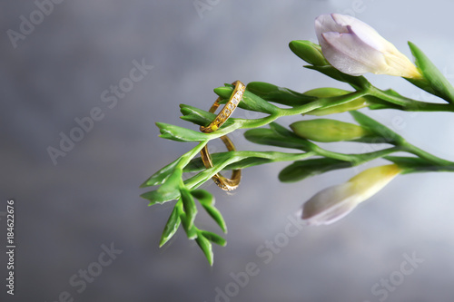 Flower with beautiful engagement ring on reflective surface