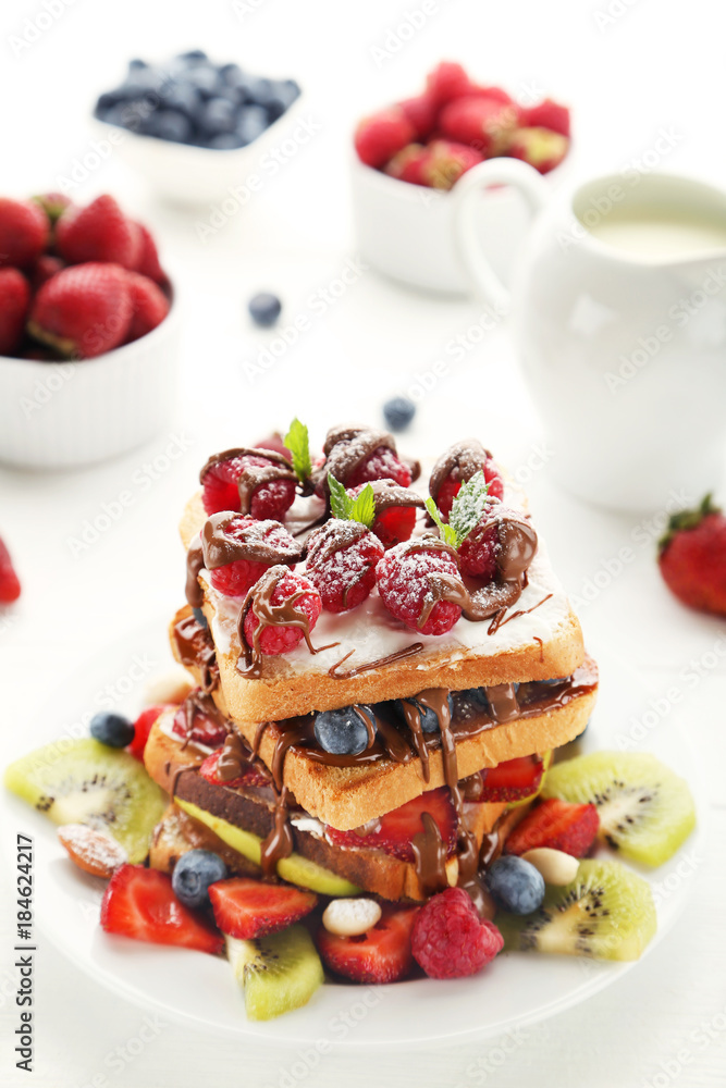 Toasts bread with berries on white wooden table