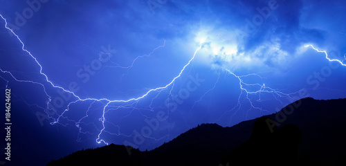 Large lightning during a powerful thunderstorm and mountains