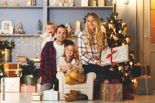 New Year's picture of happy family on background of Christmas decorations,pine