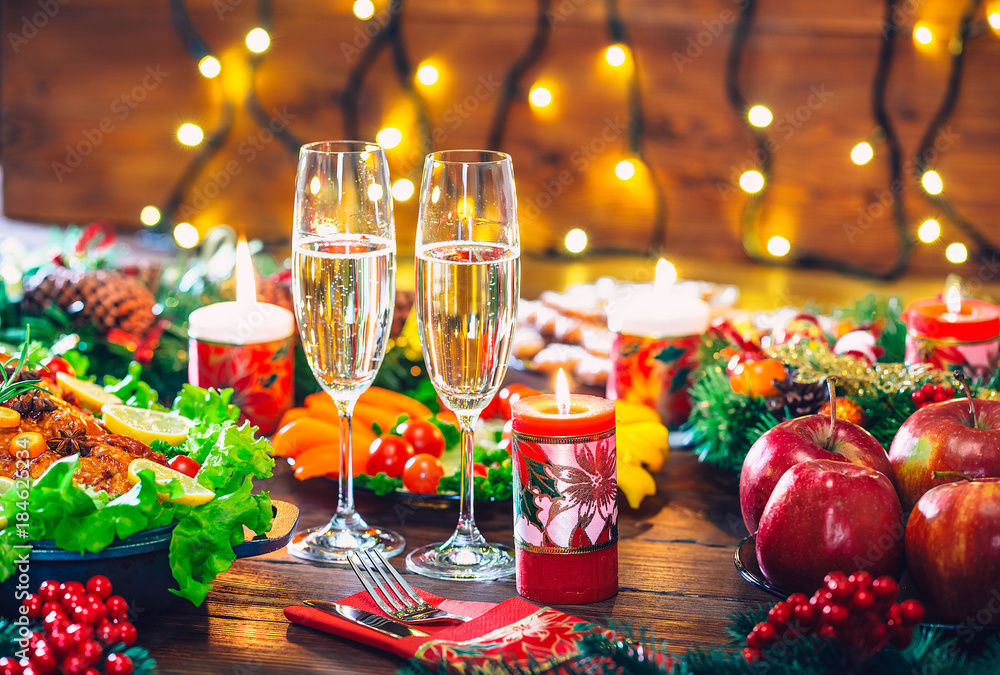 Christmas table dinner time with roasted meats decorated in Christmas style with glasses champagne. Background thanksgiving. The concept of a family holiday, delicious food.