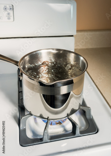 Boiling Water in Stainless Steel Pot on White Gas Stove