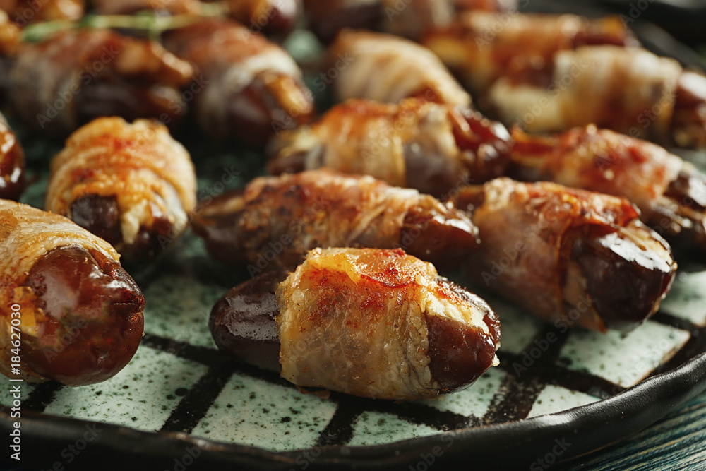 Plate with bacon wrapped dates, closeup Plate with bacon wrapped dates, closeup