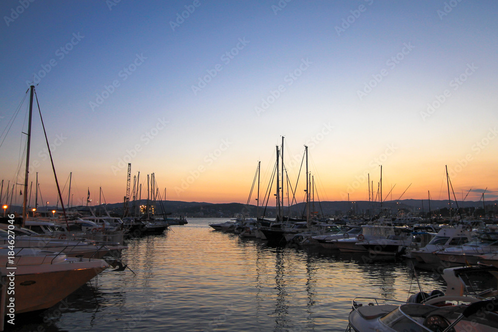 Numerous yachts in a Spanish port in the Costa Brava during sunset